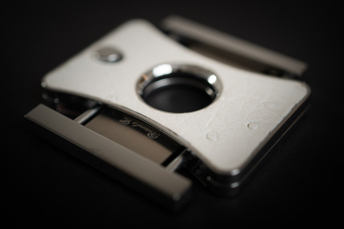 Close-up of a stainless steel double-blade guillotine cigar cutter