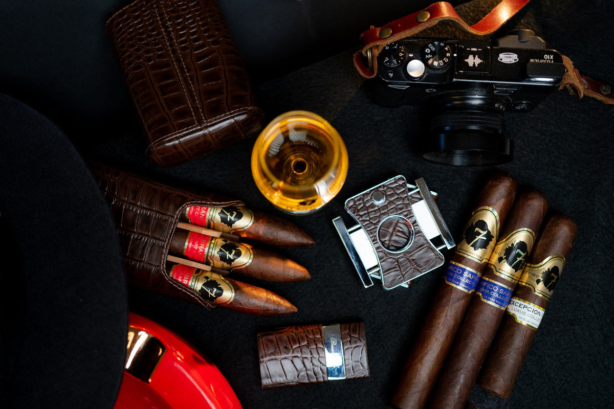 Premium cigars in a leather case with a cigar cutter, lighter and glass of cognac
