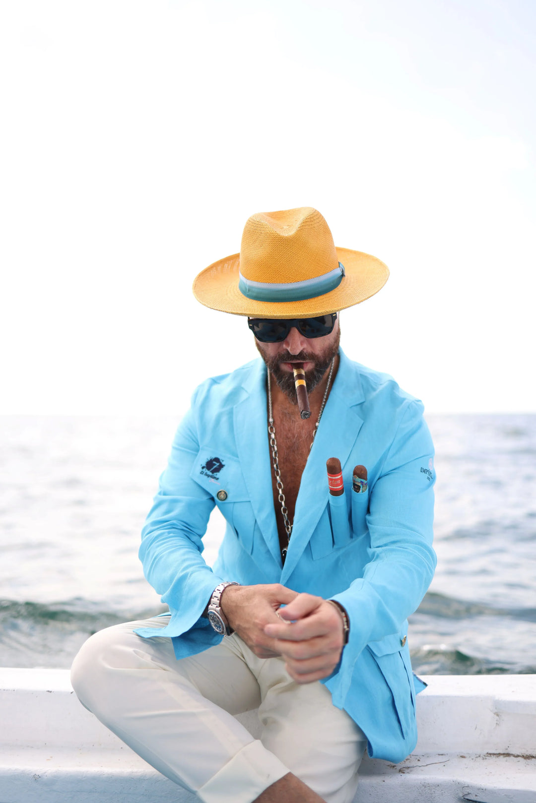 A middle aged man wearing a light blue El Septimo Smoking Suit Jacket with 3 cigar pockets and a hat available at Cigar Inc in Woodland Hills, Los Angeles