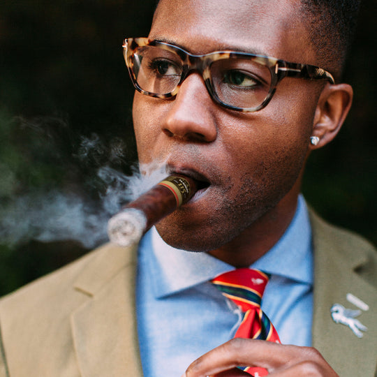 An African-American male enjoying a La Aurora 115th Anniversary Limited Edition cigar 