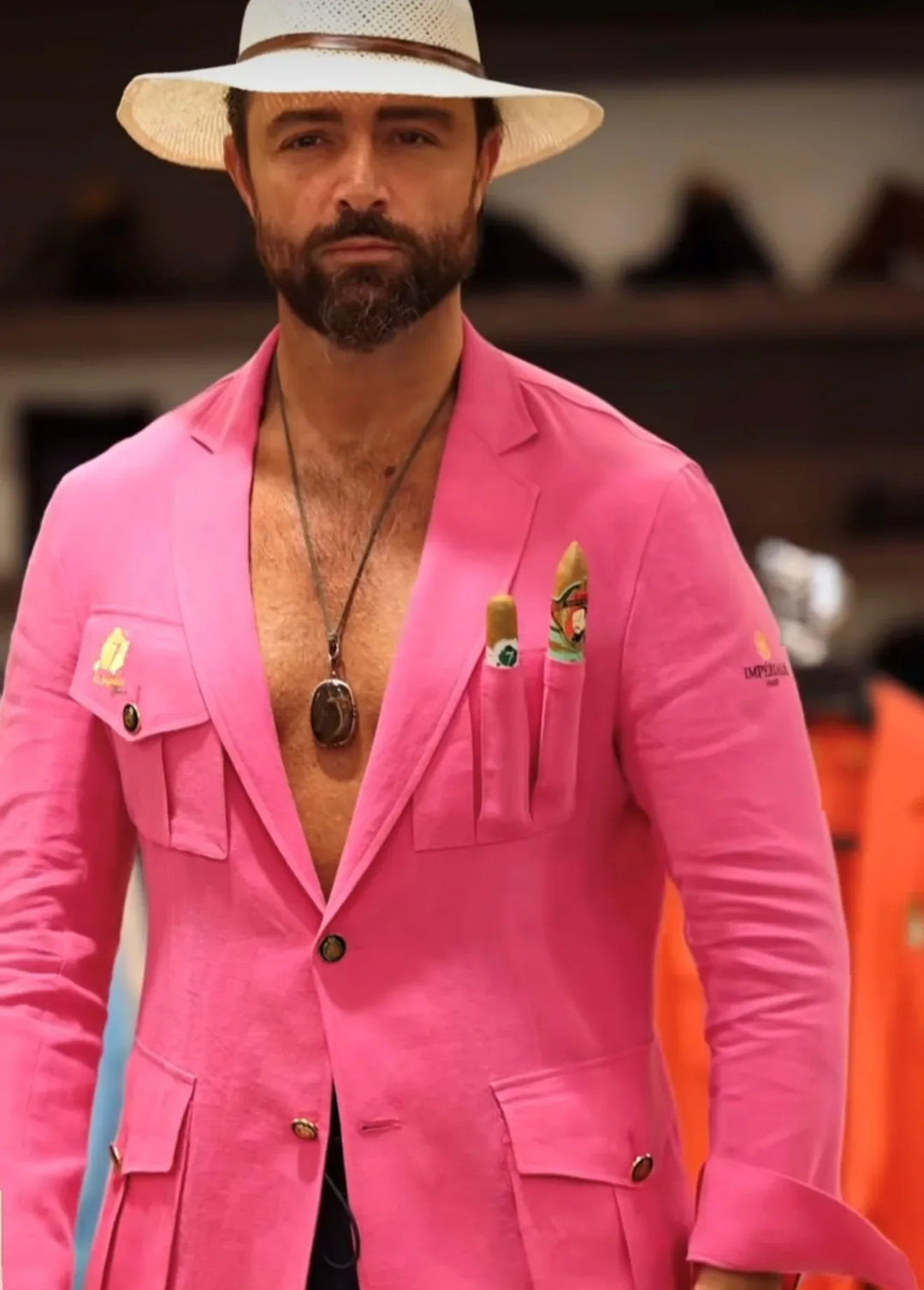 A middle aged man wearing a straw hat and a pink El Septimo Smoking Suit Jacket with 3 cigar pockets available at Cigar Inc in Woodland Hills, Los Angeles